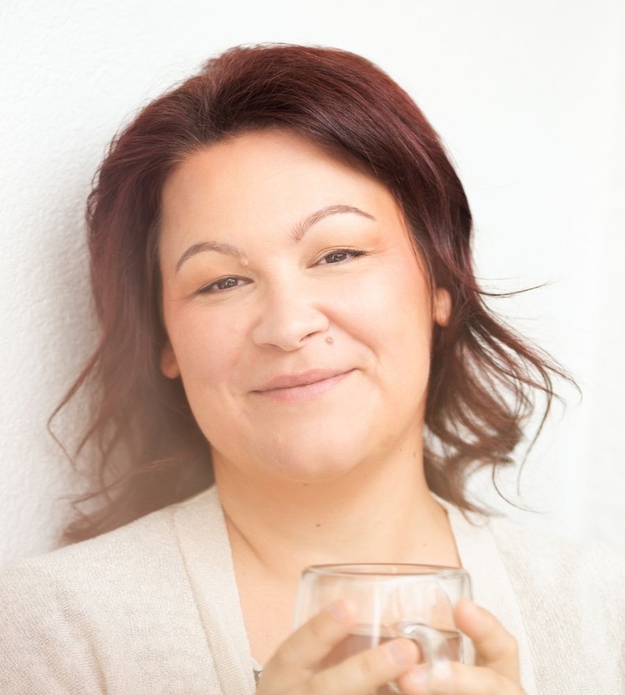 Sarah im Portrait, Locken und ein Glas in der Hand.